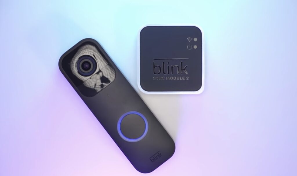 A Blink camera and a Blink Sync Module 2 on a gradient blue and purple background