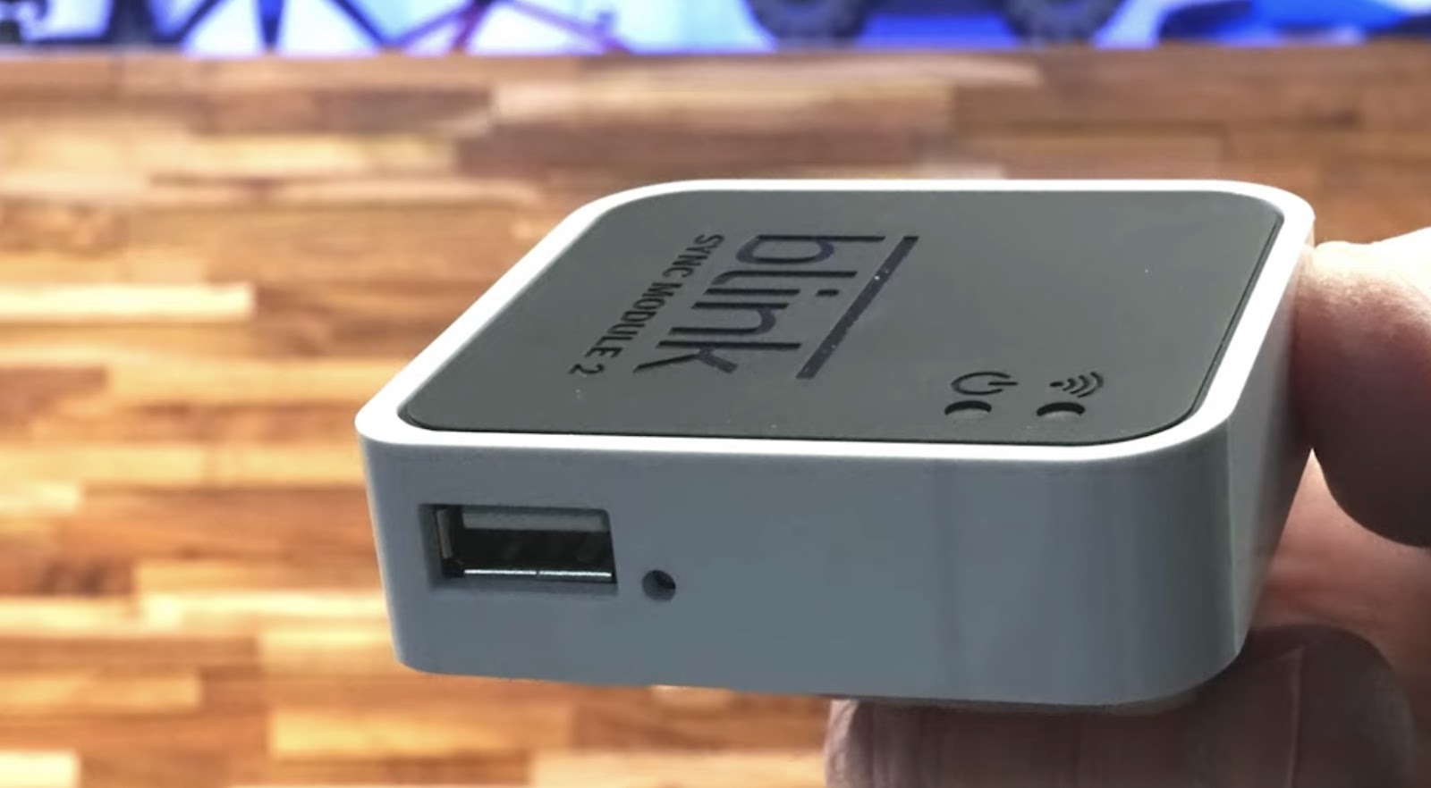 Hand holding a Blink Sync Module 2 with a USB port